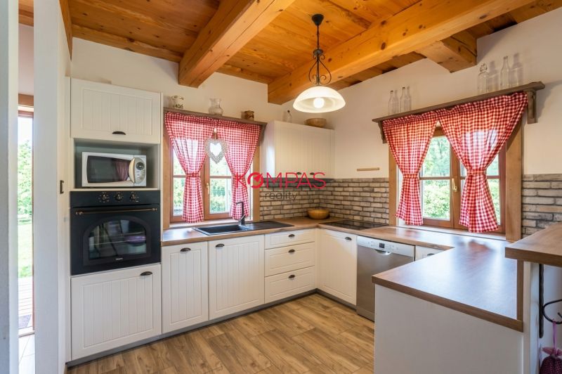 A kitchen in a family house with a brick wall and a wooden decor floor.