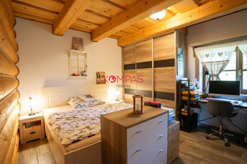 A room in a family house with a bed, a wardrobe, and a desk with a computer.