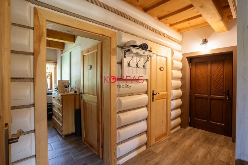 Interior of a family house with wooden walls, a floor with a wooden design, and wooden doors.