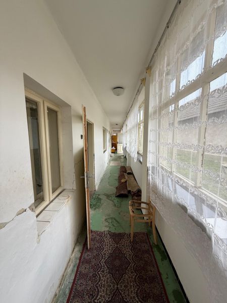 A bright hallway in a family house with carpet and curtains.