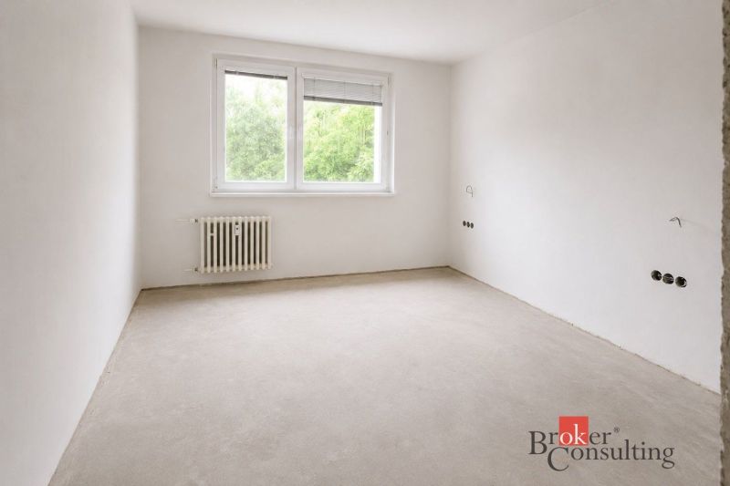 A kitchen in a 4-room apartment with a wooden decor floor and a large window.