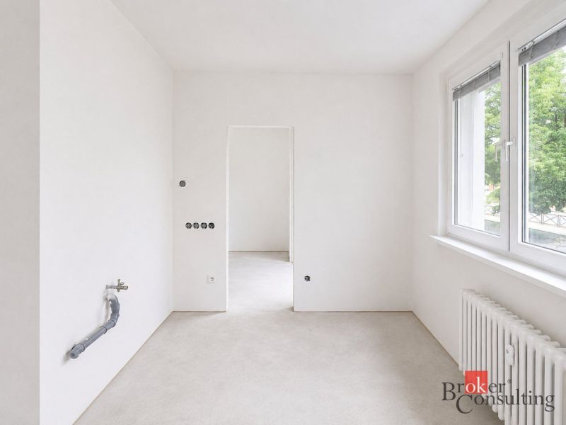 Empty room in a 4-room apartment with light walls and large windows.