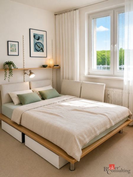 Bedroom with a bed, two pillows, minimalist decoration in a 2-room apartment.