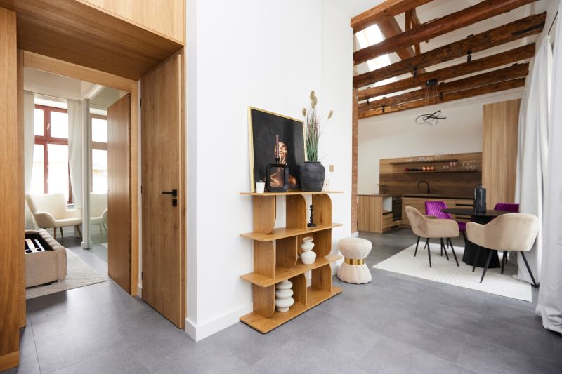 Interior of a 3-room apartment with a shelf, elegant chairs, and a floor with a wood design.