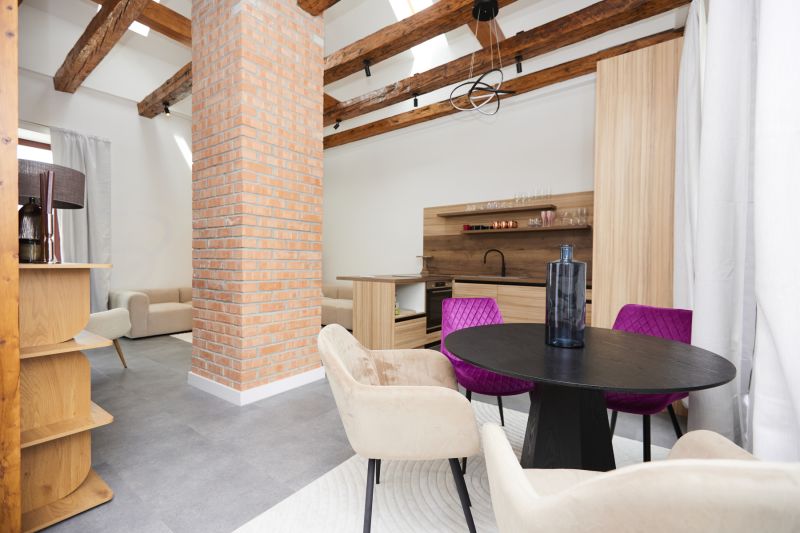 A stylish living room in a three-room apartment with a brick column and wooden beams.