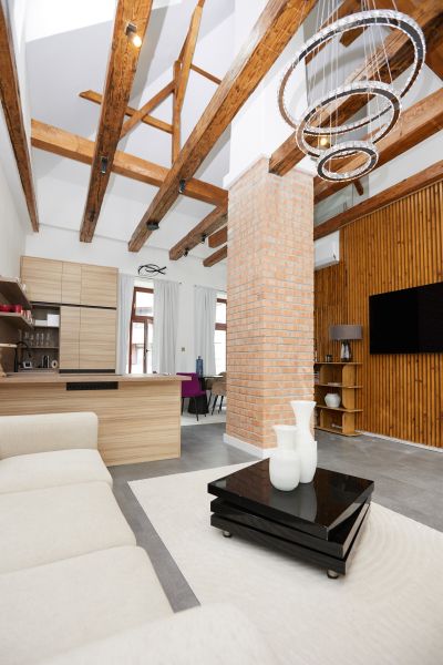 Living room in a 3-room apartment with exposed beams and a brick pillar.