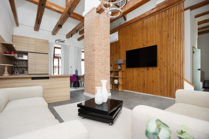 A living room with a brick wall, wooden decor flooring, and comfortable armchairs in a three-room apartment.