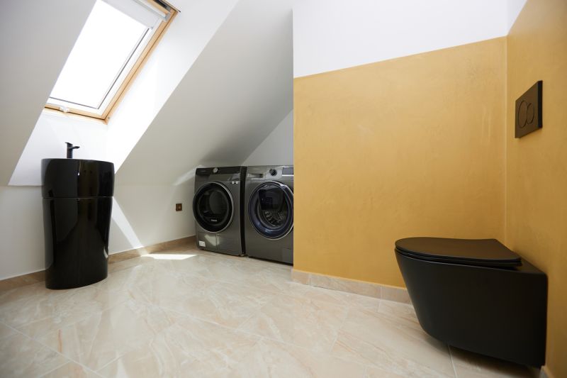 A bathroom with a black toilet, sink, and washing machines in a 3-room apartment.
