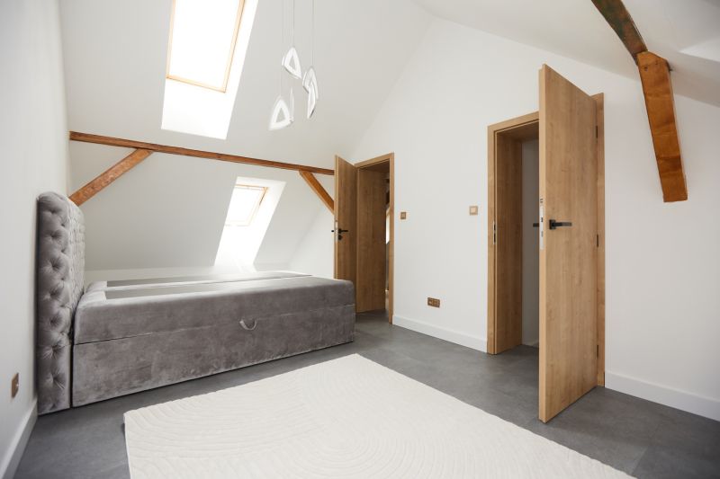 A bright bedroom with a bed, slanted skylights, and wooden elements in a 3-room apartment.