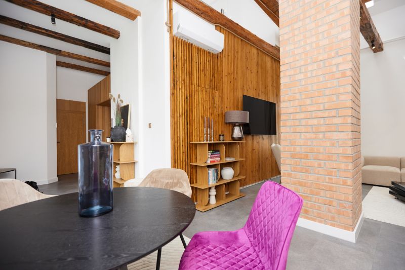 Interior of a 3-room apartment with a brick wall, wooden decor flooring, and colorful furniture.