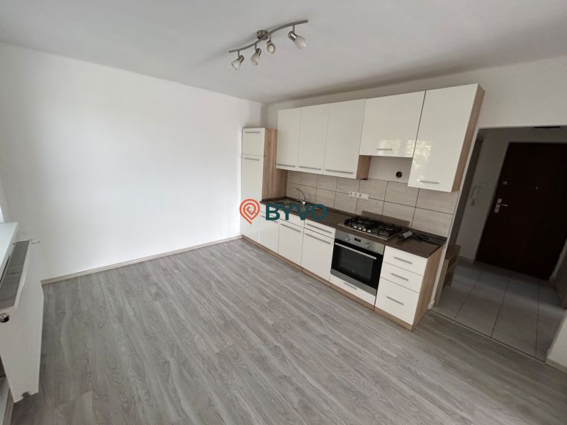 A kitchen in a 3-room apartment with built-in appliances, flooring with a wooden decor.