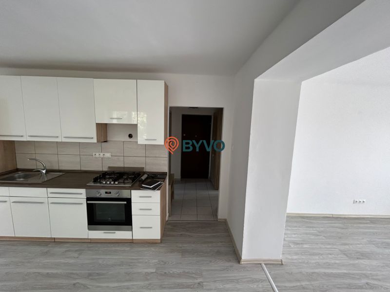 A kitchen unit with a wooden decor in a 3-room apartment, a space with white walls.