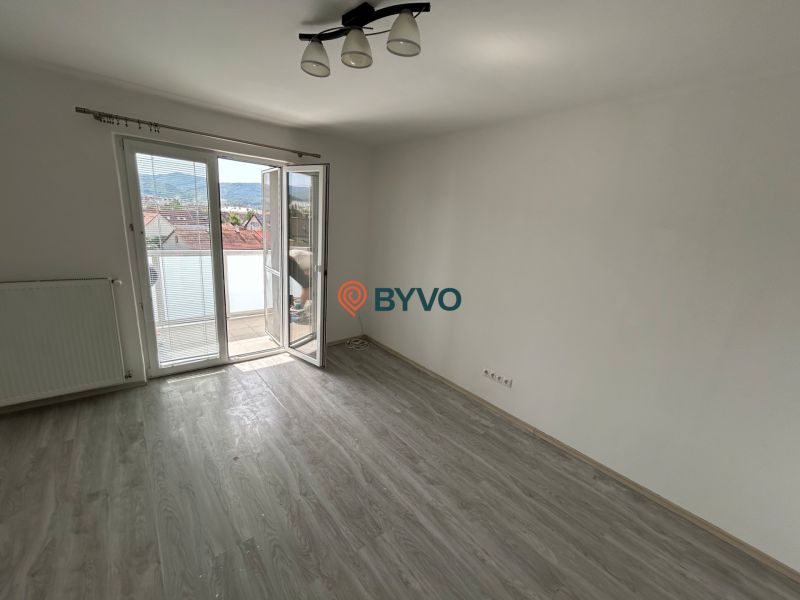 A room in a 3-room apartment with a wood-patterned floor and a balcony.