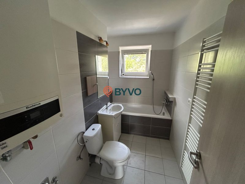 Bathroom in a 3-room apartment with a bathtub, sink, toilet, and ladder radiator.