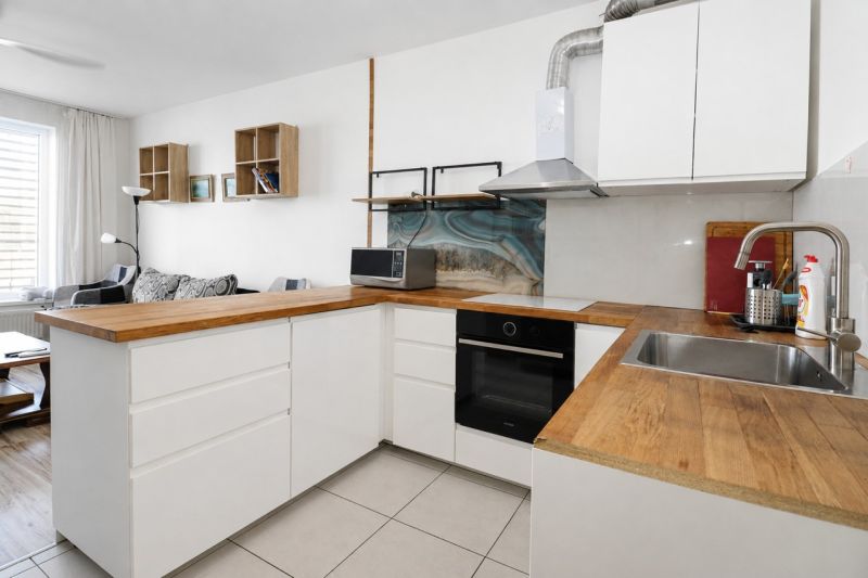 A kitchen with wooden decor and a sofa in a 2-room apartment.