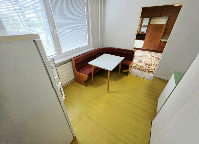 A kitchen in a 3-room apartment with a corner bench and table.