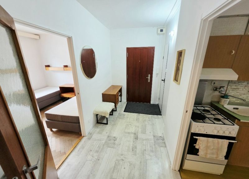 Entrance hall of a 3-room apartment with a kitchenette and a view into the bedroom.