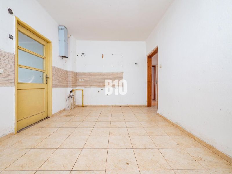An empty room with tiles and yellow doors in a family house.