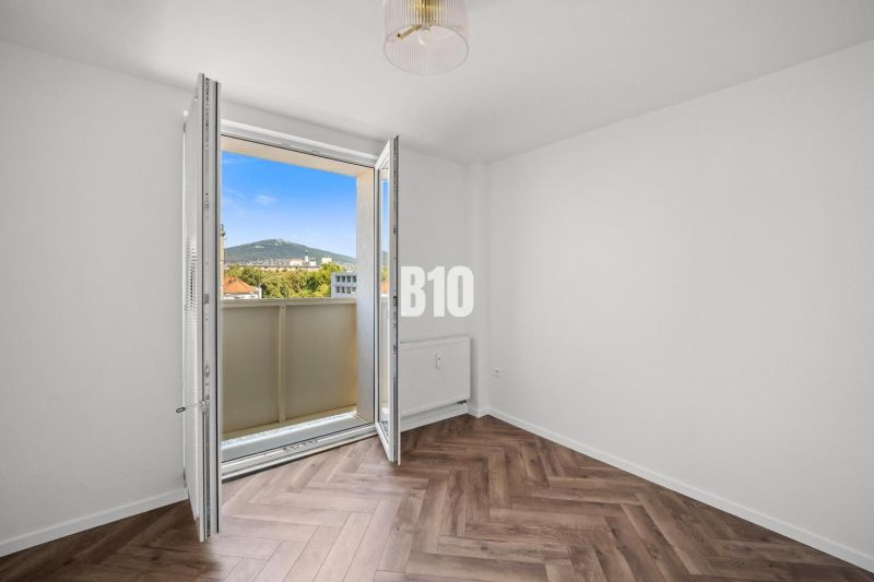 A room in a 3-room apartment with a view and a floor with a wooden decor.