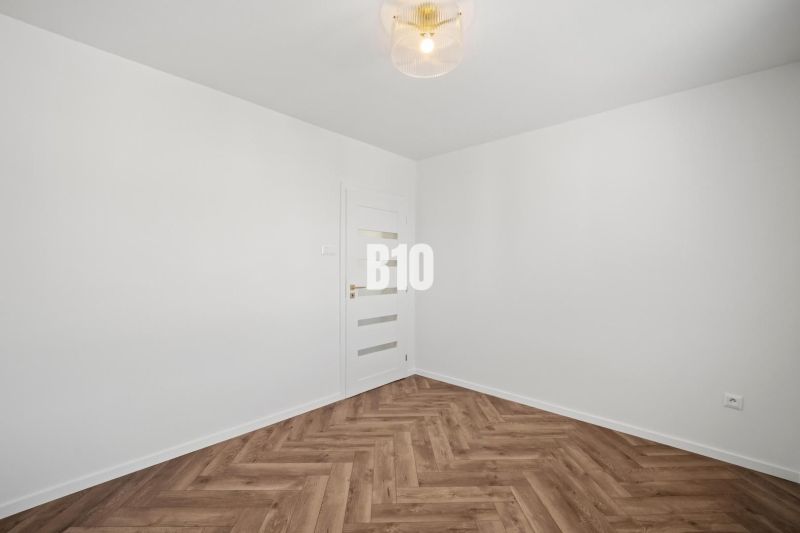 White wall and floor with wood decor in a 3-room apartment.