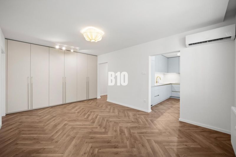 Living room in a 3-room apartment with a wooden decor floor and a built-in wardrobe.