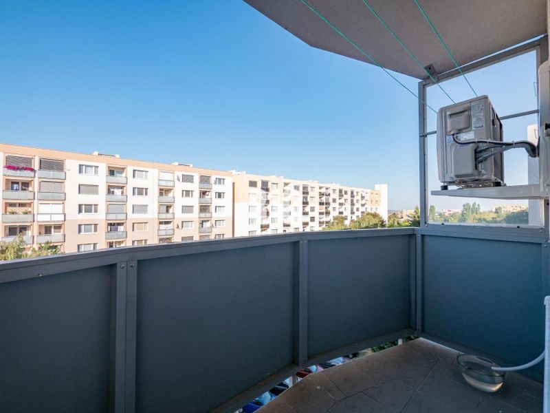 A view from the balcony of a one-room apartment in Nitra overlooking the surrounding apartment buildings.