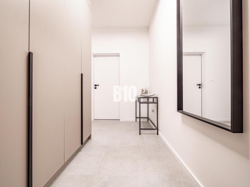 Hallway with a mirror and white walls in a family house.