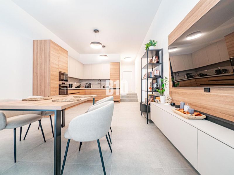 Kitchen with dining room in a family house, light walls, wooden decorations, dining table.