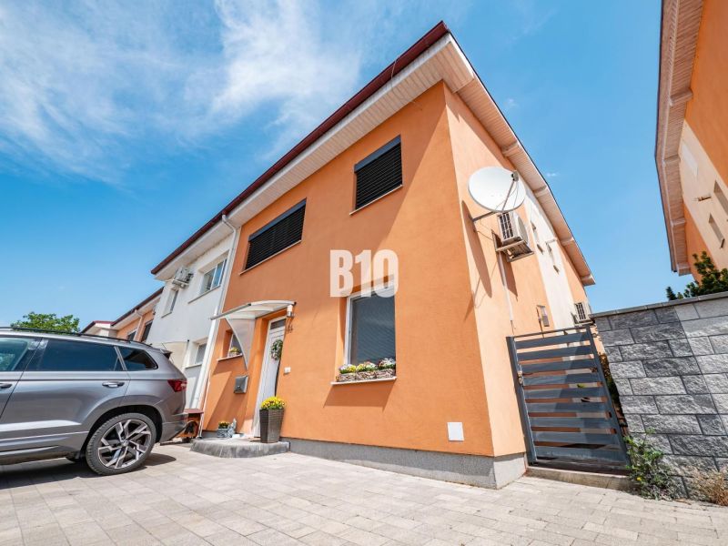 A family house in Nitra with an orange facade and a car in the yard.