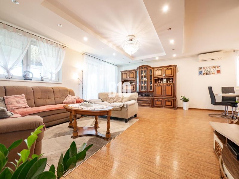 Interior of a family house with a living room, light curtains, and a floor with a wooden decor.