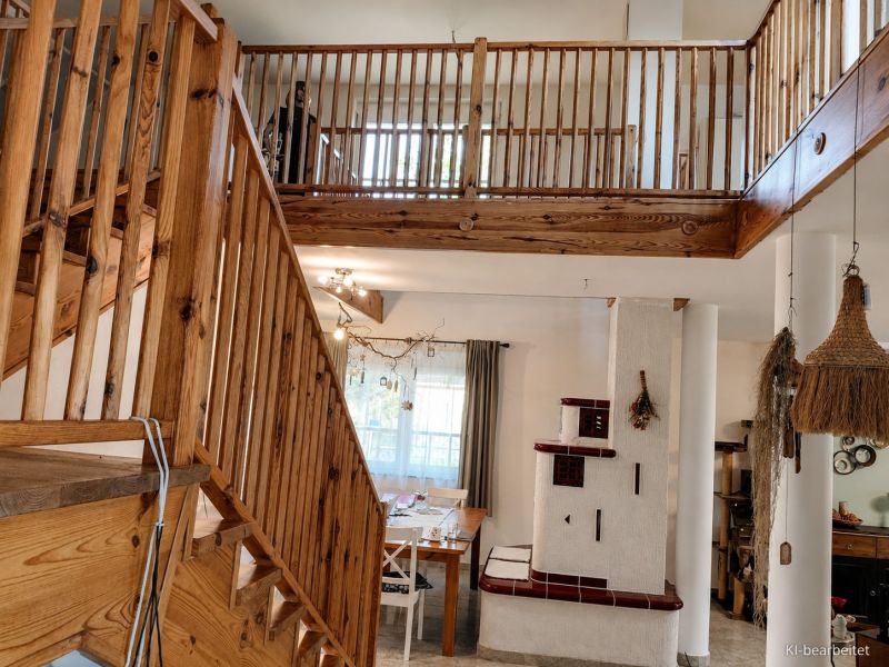 Interior of a family house with a staircase and a fireplace, floor with wooden decor.