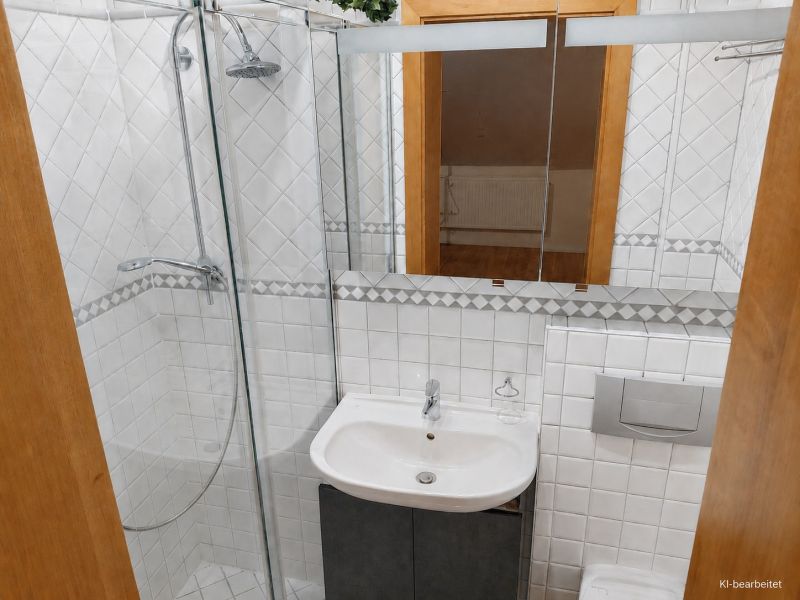 A bathroom in a family house with white tiles and a shower corner.
