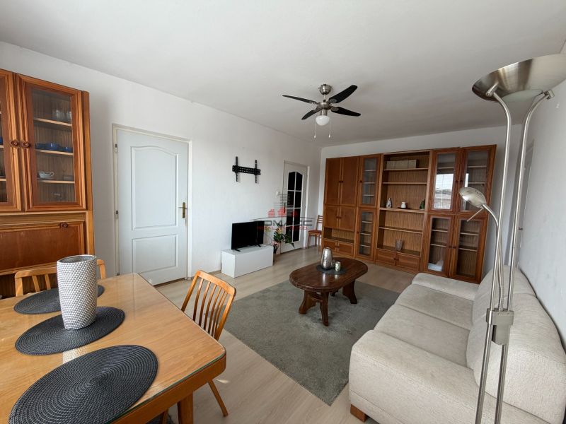 A living room of a three-room apartment with wooden furniture and a floor with a wooden decor.