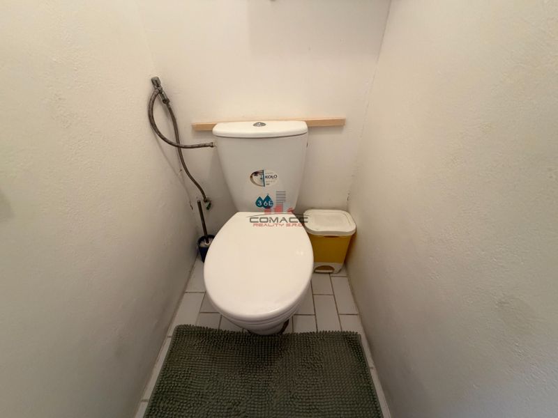 A bathroom of a 3-room apartment with white walls and tiles.