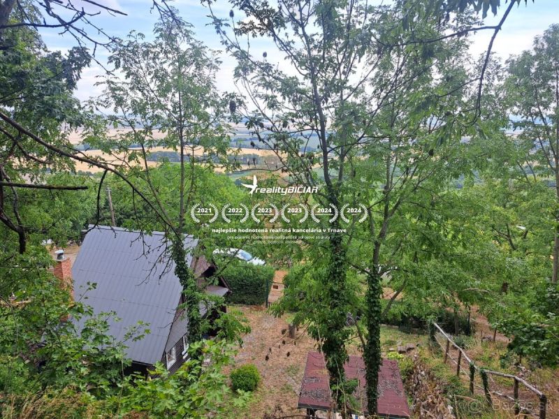 A cottage in Dolné Orešany surrounded by trees, with a view of nature from Dolné Orešany.