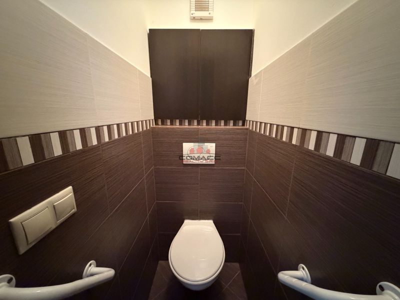 A toilet with patterned tiles in a 3-room apartment.