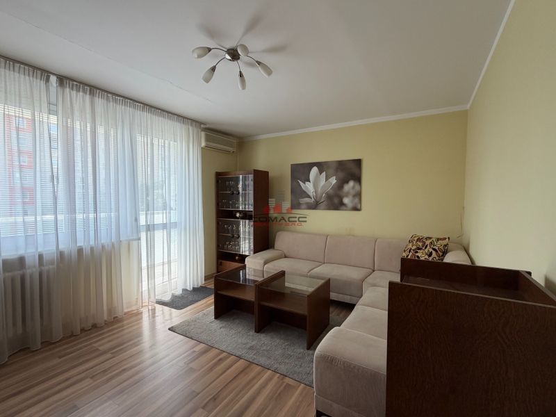 Living room in a 3-room apartment with a sofa and a wooden decor floor.