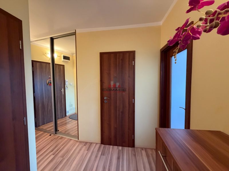 A hallway in a 3-room apartment with a wooden decor floor and a built-in wardrobe.