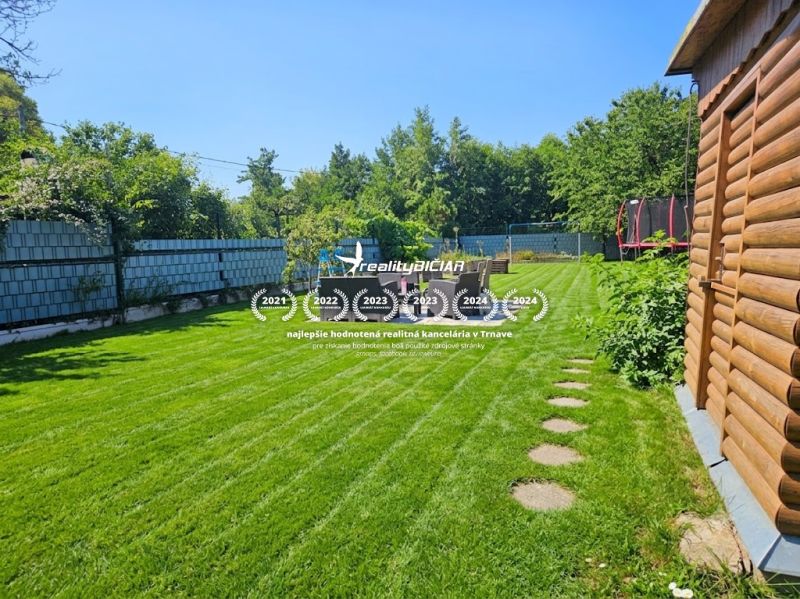 Garden at Kamenný Mlyn in Trnava with a garden house and a trampoline.