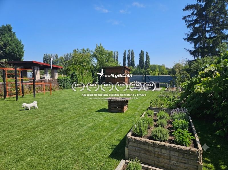Garden in Kamenný mlyn, Trnava with a green lawn and raised beds.