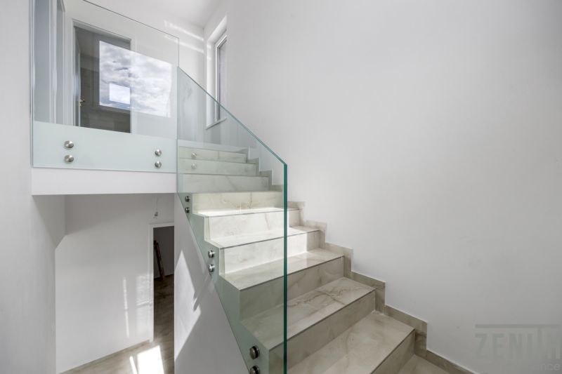 Glass railing with staircase in a family house, bright room, simple design.