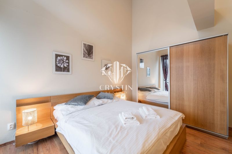Bedroom with a bed and wood-patterned flooring in a holiday apartment.