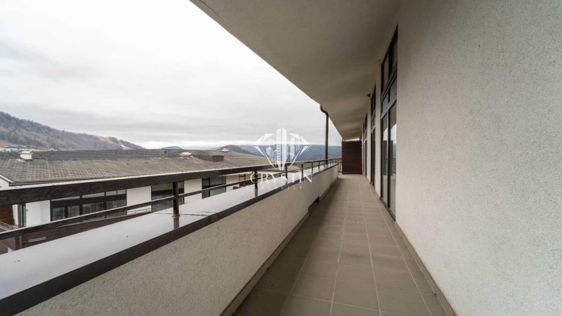 The balcony of the recreational apartment in Donovaly offers a view of the surrounding mountains and rooftops.