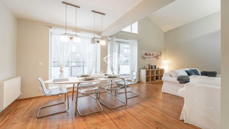 Recreational apartment with a dining table, comfortable sofas, and a wooden decor floor.