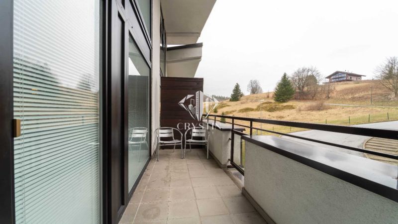The balcony of a recreational apartment in Donovaly with a view of nature and cottages.