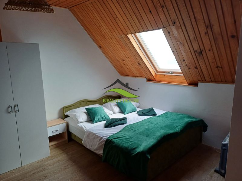 Attic room in a cottage with a double bed and a skylight.
