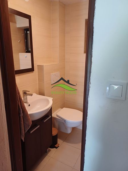 A bathroom in a cabin with a sink, toilet, and light tiles.