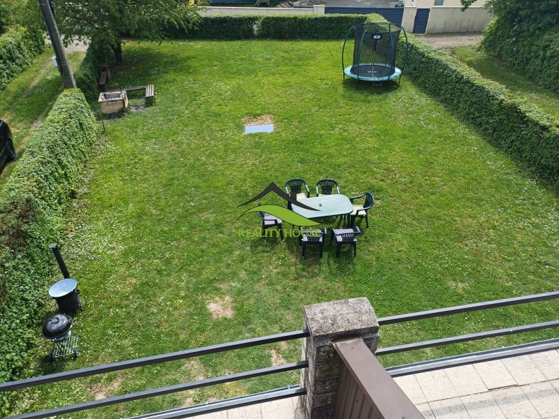 A garden by the cottage in Kaluža with a trampoline and seating on the grass.