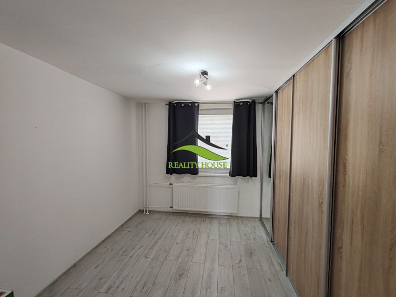 A room in a 3-room apartment with a wooden decor floor and a built-in wardrobe.