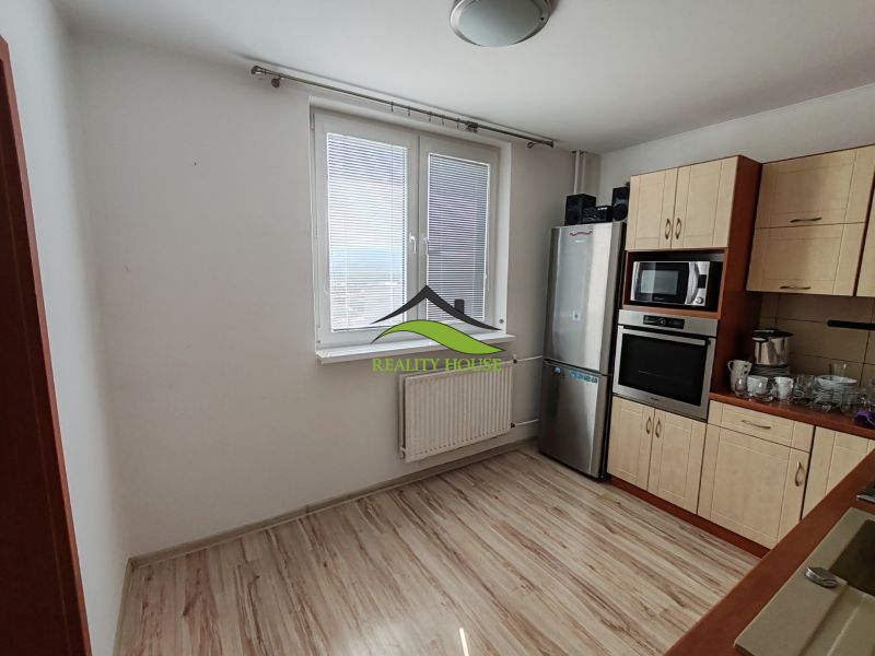 A kitchen in a 3-room apartment with a window and a floor with a wooden decor.